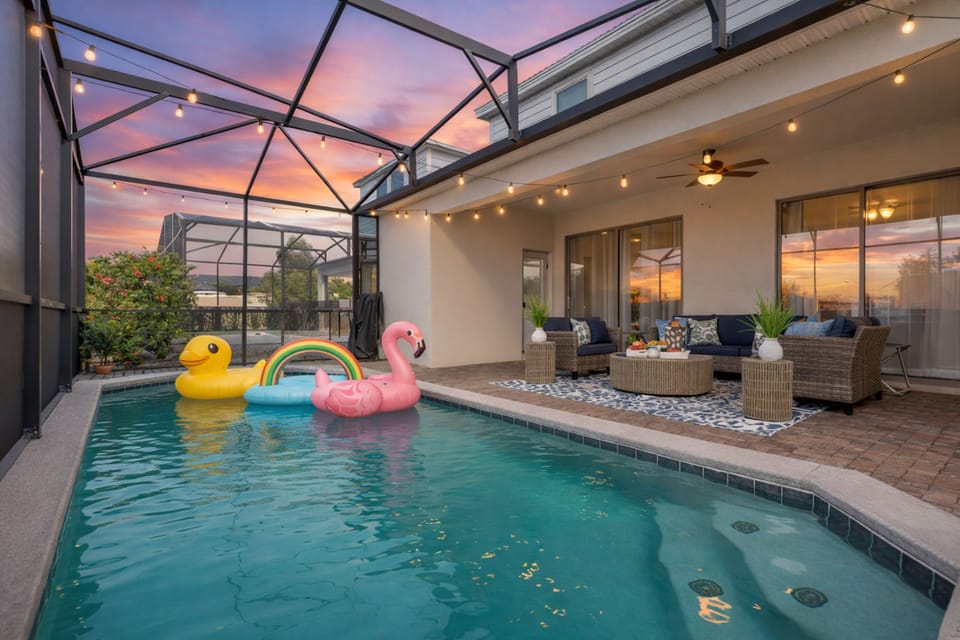 Screened private pool with string-lit lounge—sunset-ready retreat