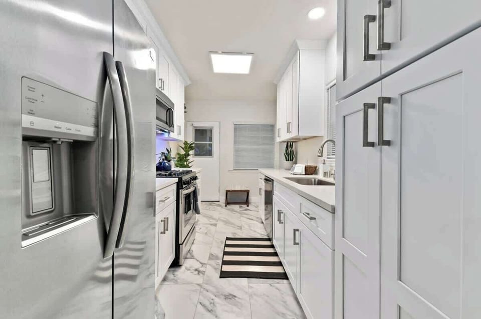 Kitchen and large refrigerator, providing ample storage for your culinary delights, ensuring your ingredients remain fresh and easily accessible throughout your stay...