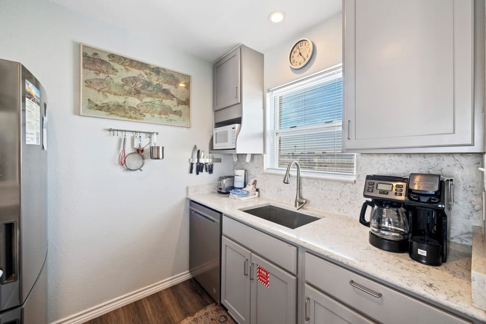 Your modern kitchen awaits with marble countertops, stainless appliances, and coffee maker for perfect morning brews.