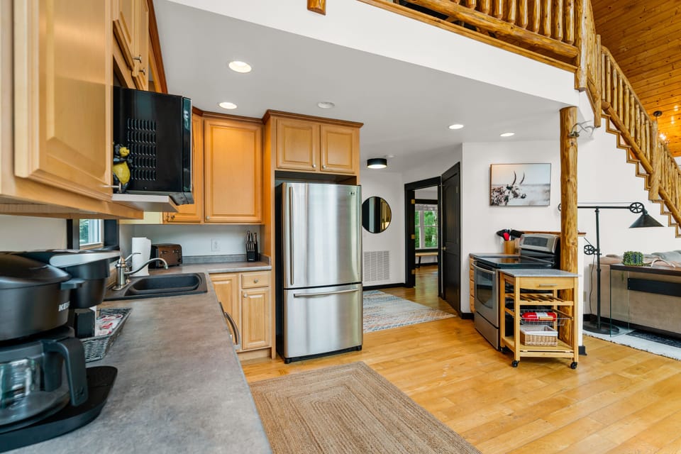 The open kitchen has newer full size stainless steel appliances.