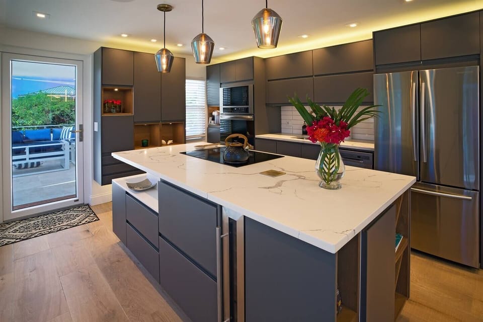 Modern and well-equipped kitchen.  The entry door leads to another patio with grill and outdoor dining table.