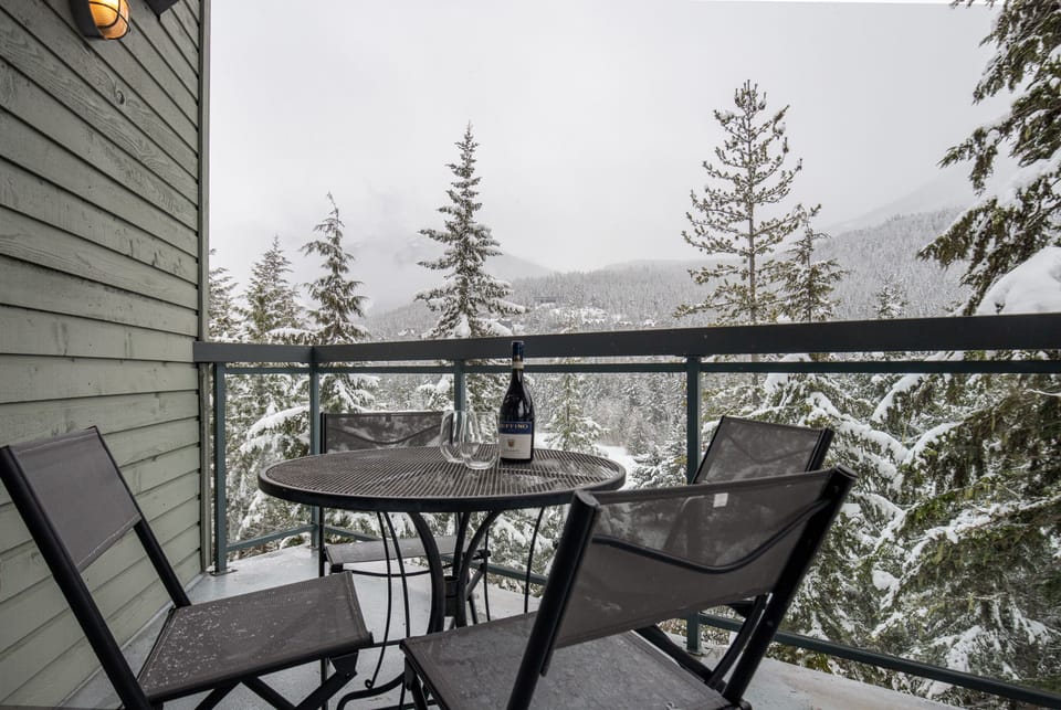 Outdoor patio with views of Whistler Mountain and snowy hillsides in the winter
