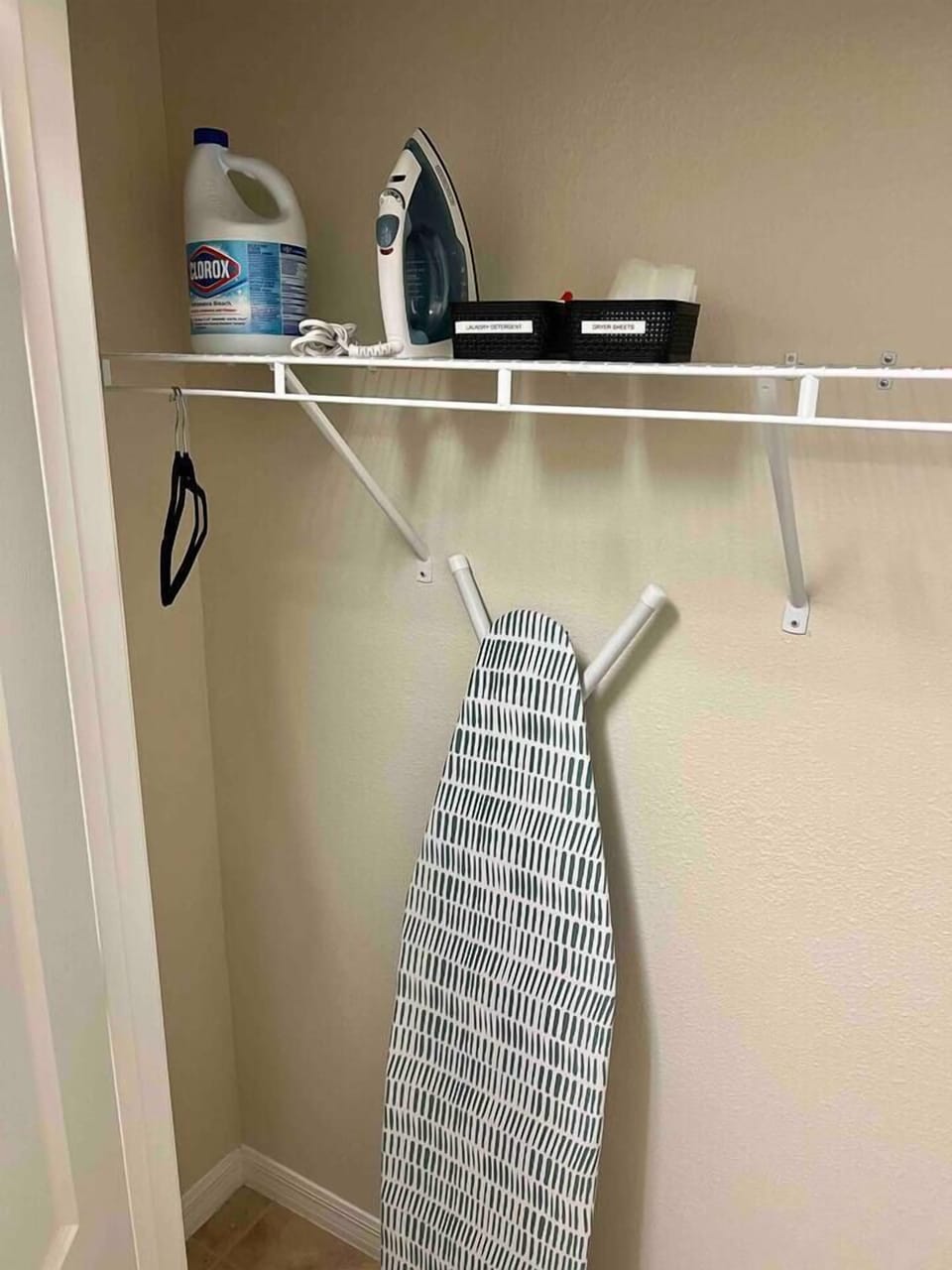 Laundry room closet with iron, ironing board, and other supplies