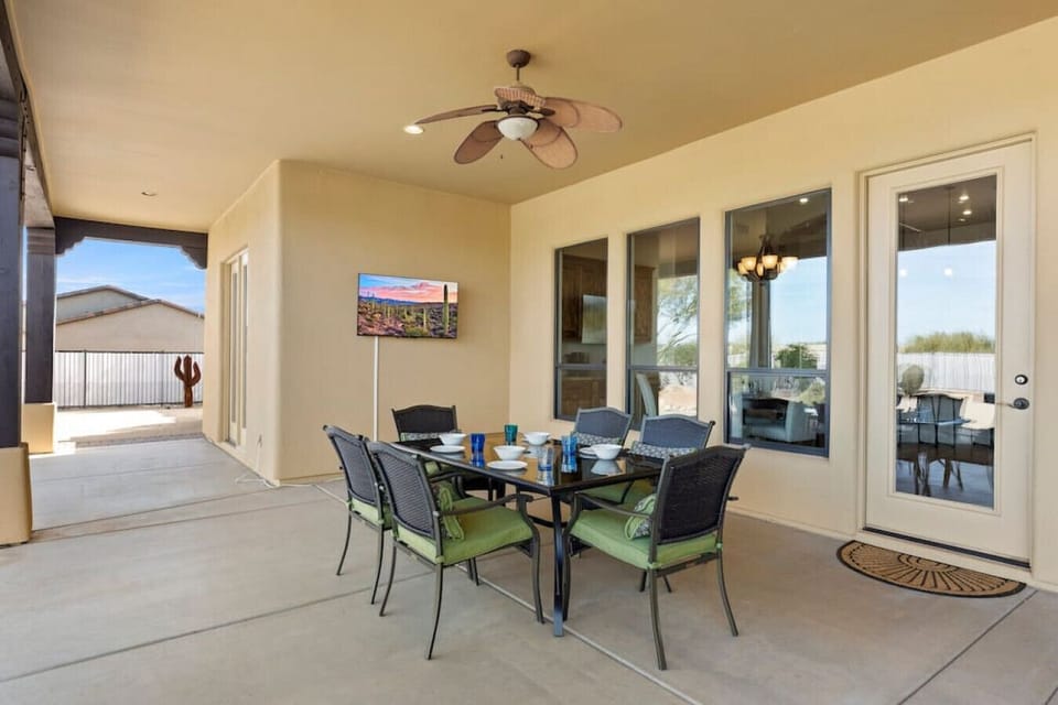 Covered back patio space with dining area and TV