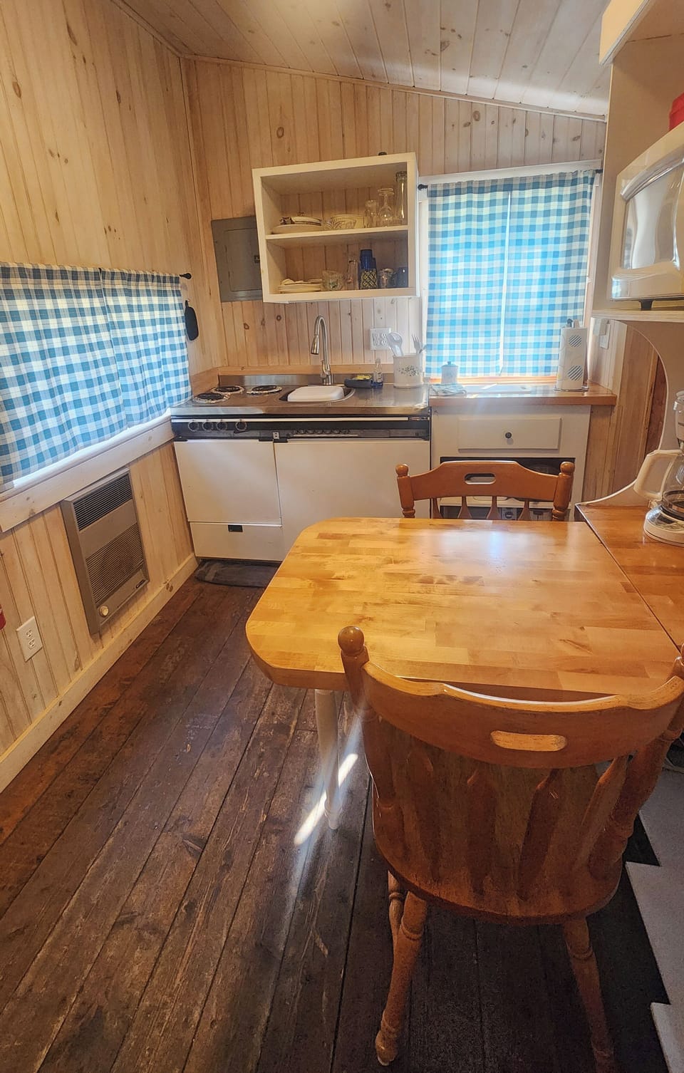 Kitchen area includes table for 2 with storage case, microwave and coffee pot