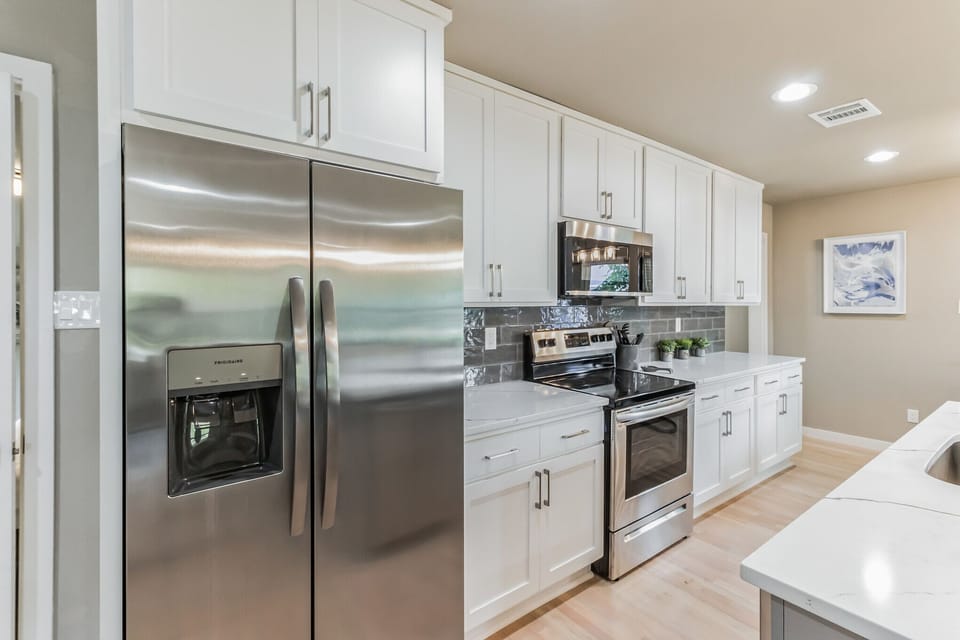 Fully stocked kitchen with new SS appliances, quartz tops & tile backsplash