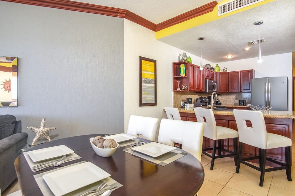 there dining table sits next to the kitchen counter, with its matching upholstered chairs
