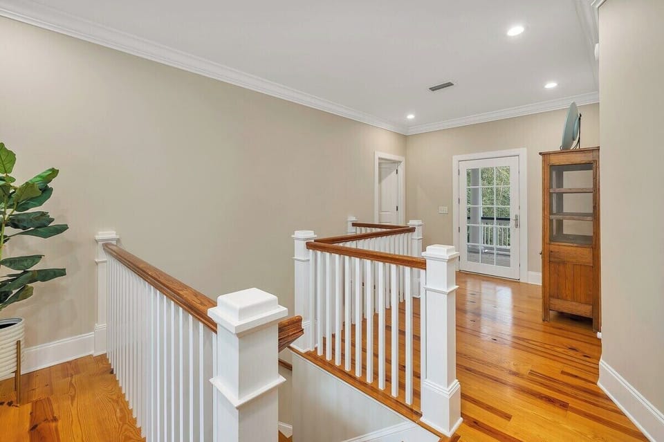 Upper landing with wood railing and hallway view