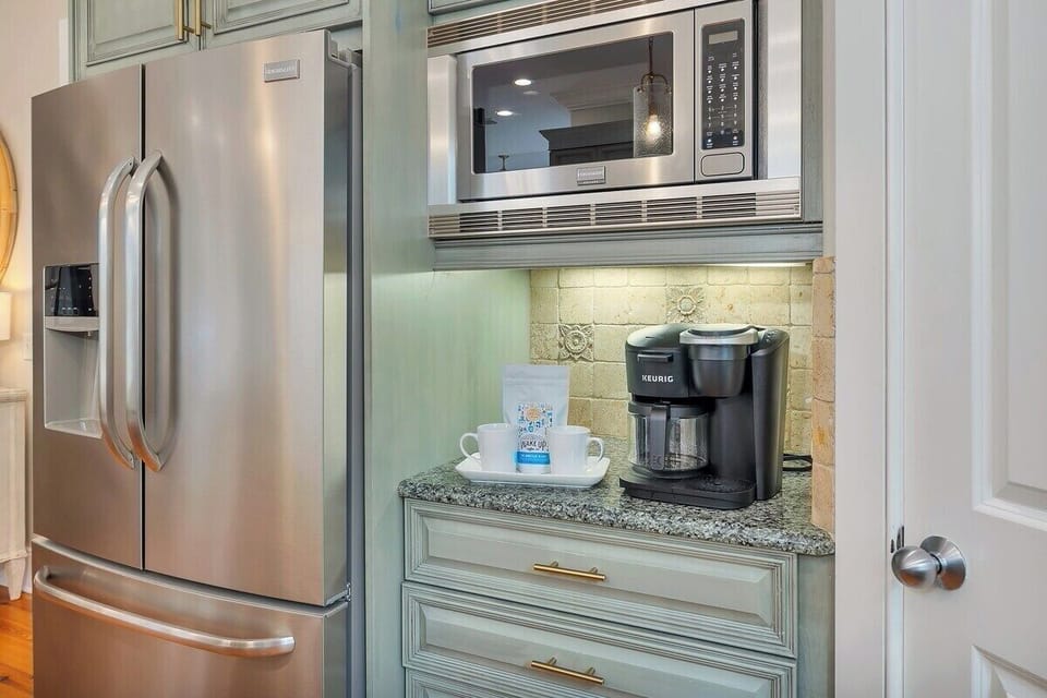 Stainless refrigerator, microwave, and coffee station close-up