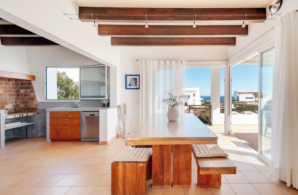 Comedor y cocina con acceso al jardín y vistas al mar