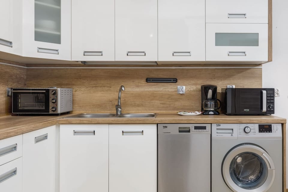 Another angle of the kitchen showcasing ample storage, modern design, and a full-sized fridge.