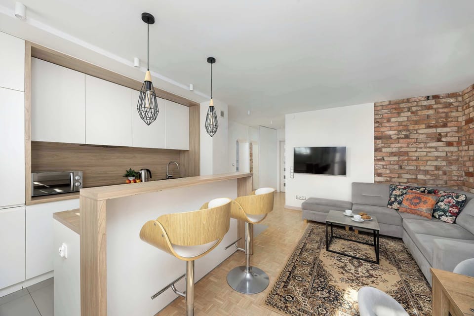 A combined living and dining space with a sofa in the foreground and a kitchen visible in the background. The open-plan layout enhances functionality.