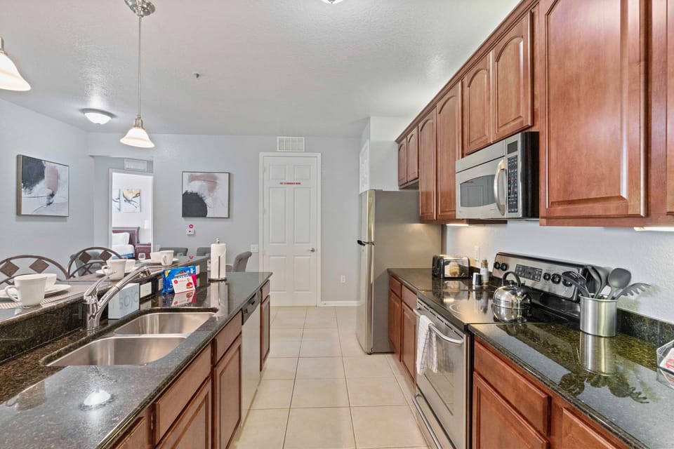 Modern Kitchen of the condo in Orlando - Fully equipped with all kitchen accessories - Stainless steel appliances available - Sufficient storage space in beautiful wooden cupboards