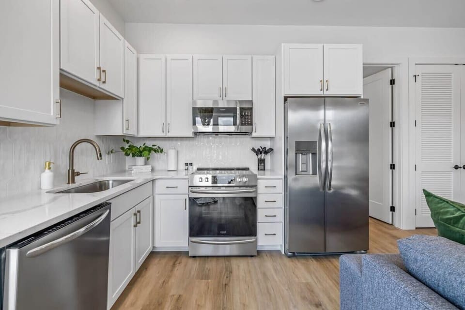 Enter this welcoming kitchen, where the vibrant blue couch provides a refreshing burst of color against the timeless backdrop of white cabinets, creating an inviting and harmonious space.