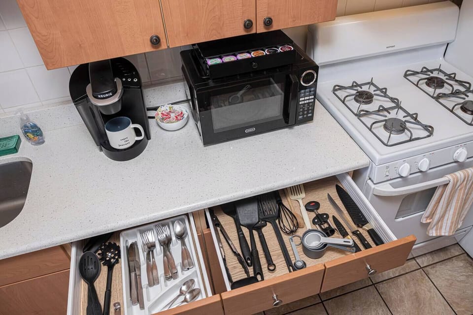 Fully stocked kitchen with Roku coffee maker, oven and microwave.