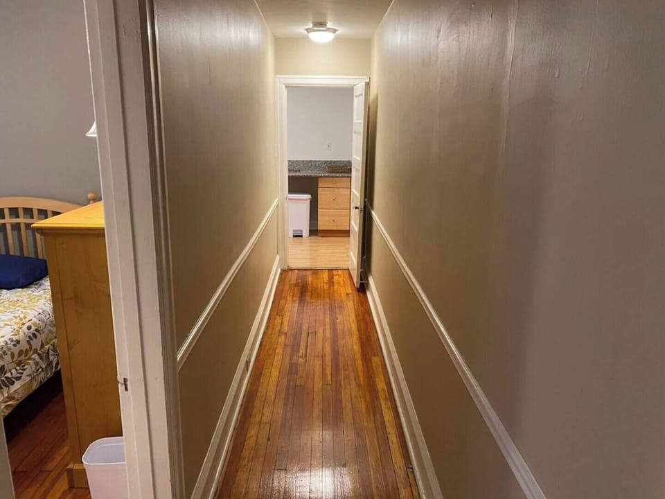 A long hallway with beautiful finished wood floors leads from the kitchen to the back bedrooms.