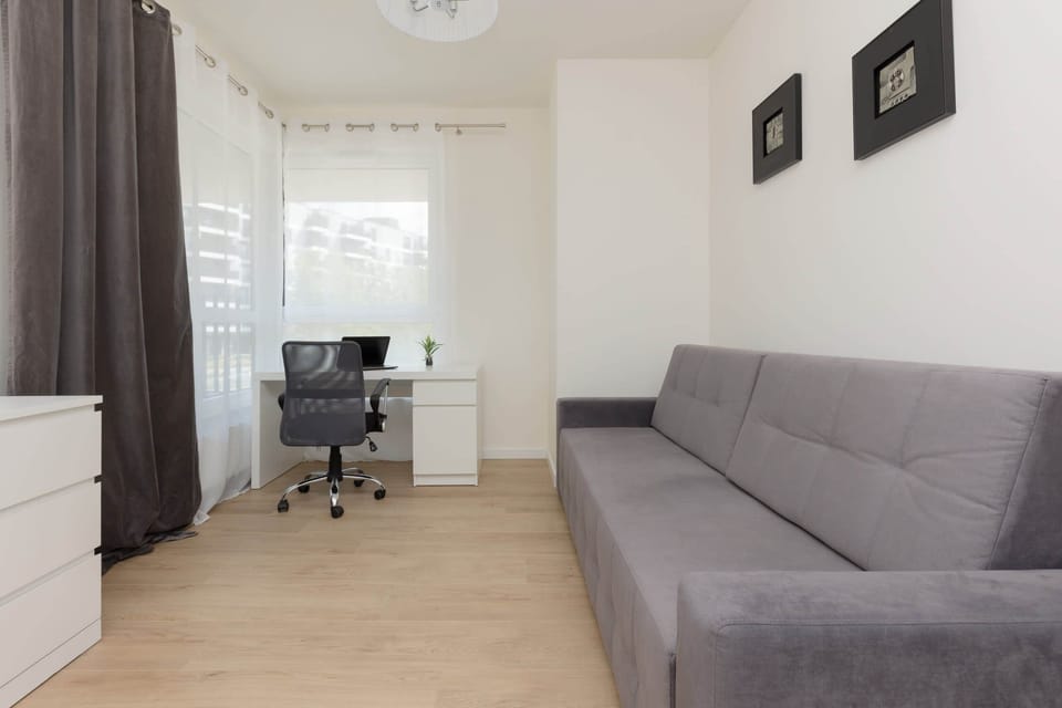 The stylish bedroom includes a comfortable sofa bed and a desk.