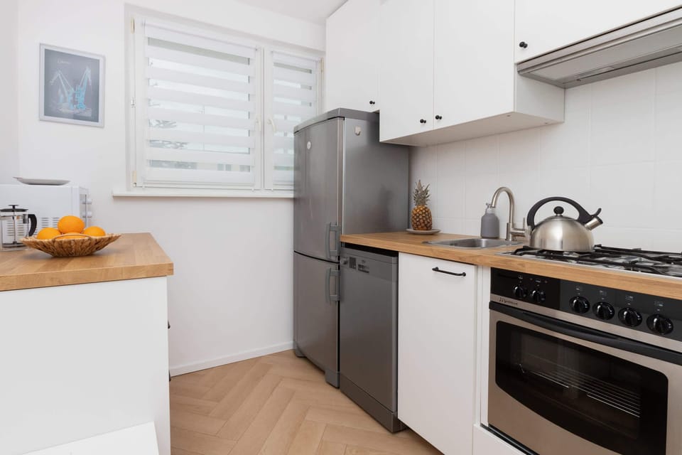 Functional kitchen with white cabinets, a modern oven, and plenty of cooking space.