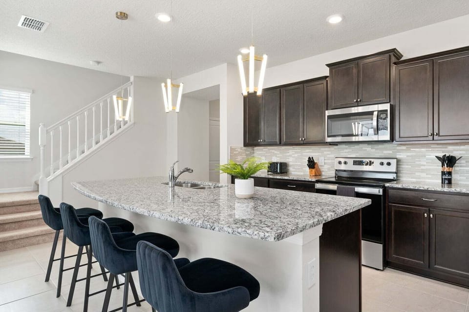The kitchen area also integrates with the rest of the house, allowing easy interaction with guests in other living spaces.