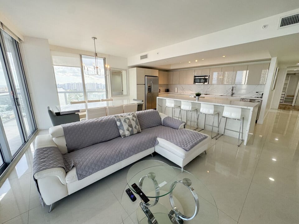 Bright living room with balcony access and city views.