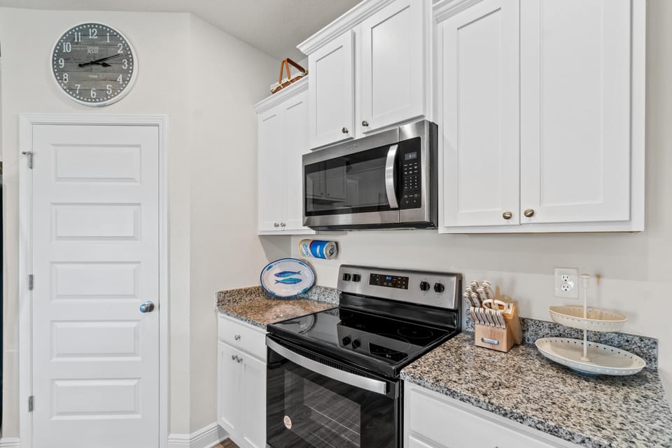 Whip up your favorite meals in this bright, fully-equipped kitchen featuring granite countertops, stainless steel appliances, and all the essentials for your stay.