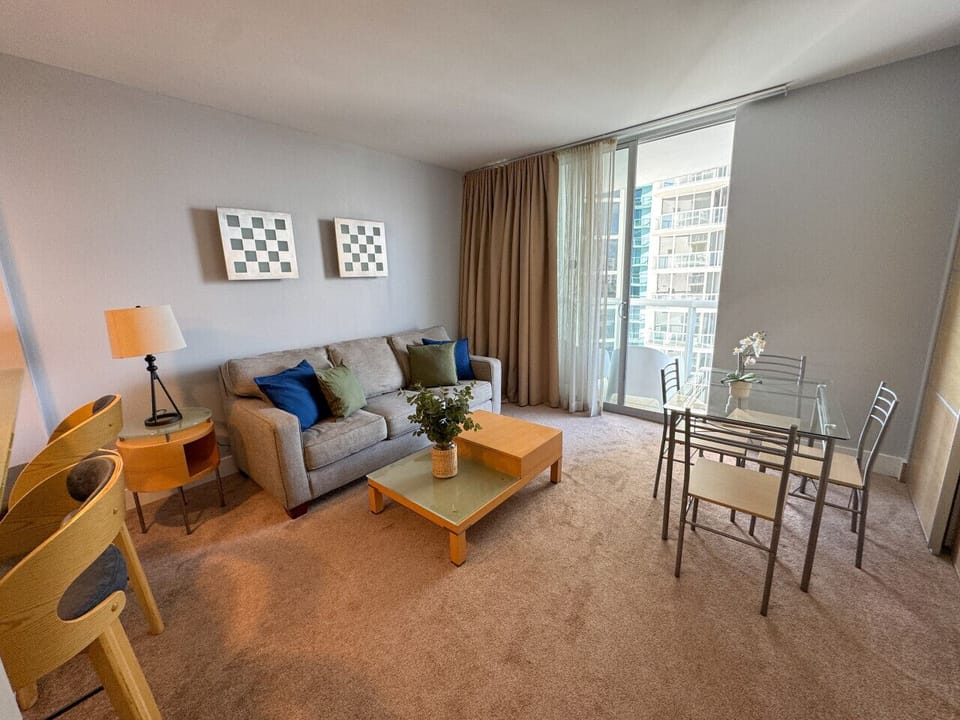 Bright living room with balcony access and city views.