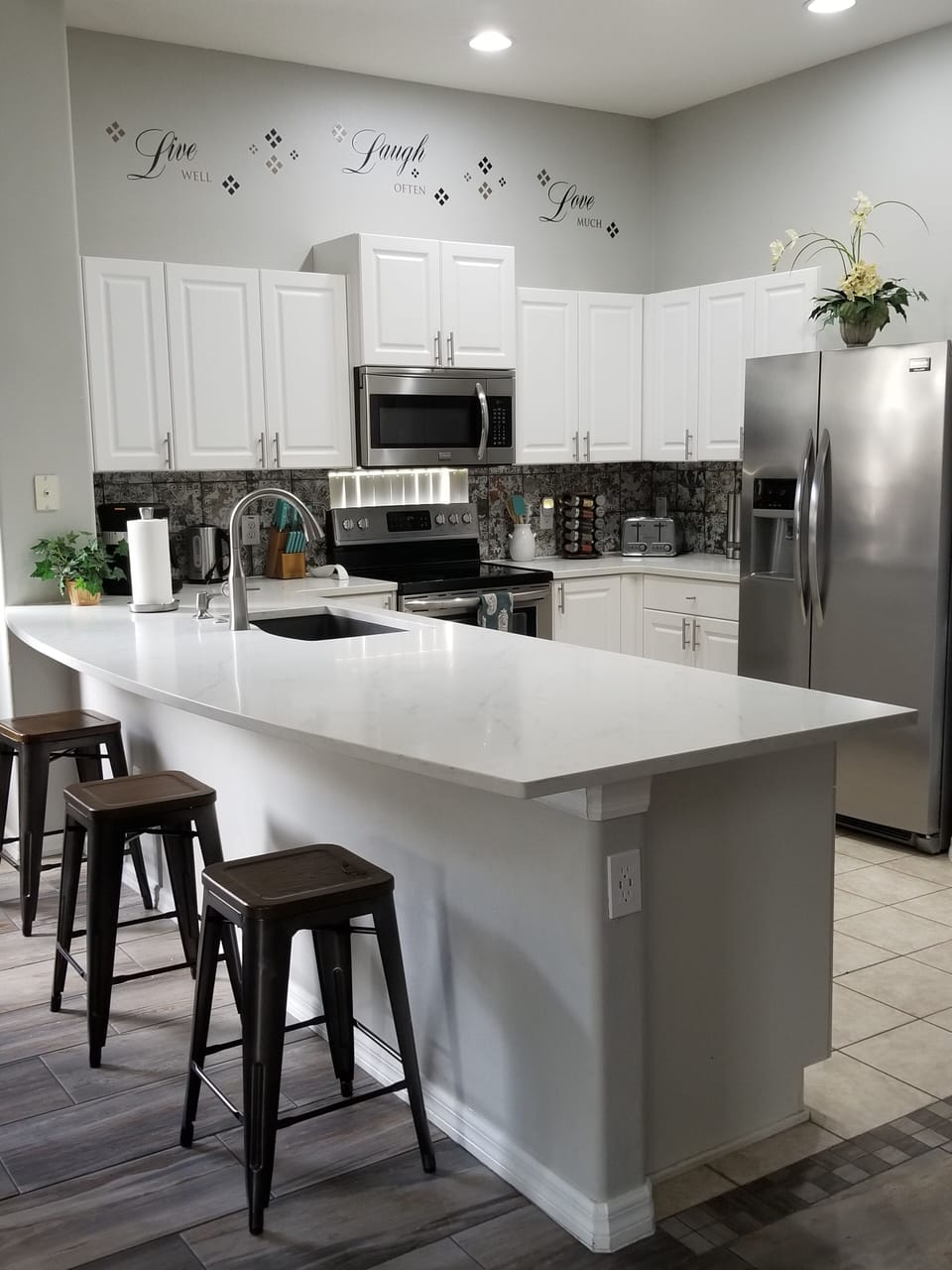 Quartz counters w/ granite sink, stainless appliances, peninsula & breakfast bar