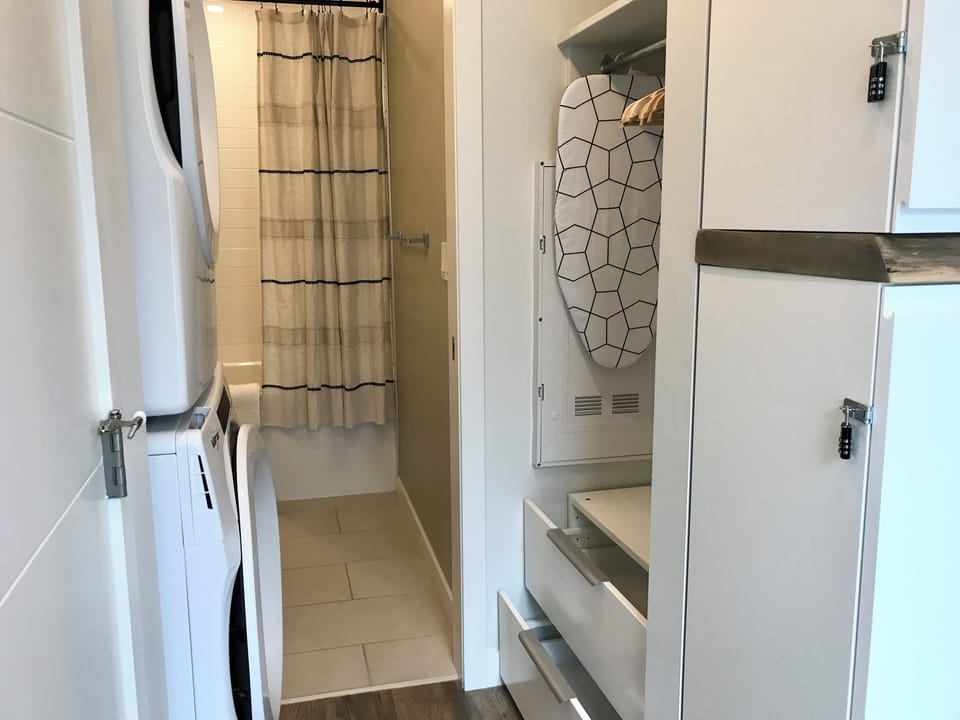 Full-size washer/dryer and closet nook with hanging and drawer storage