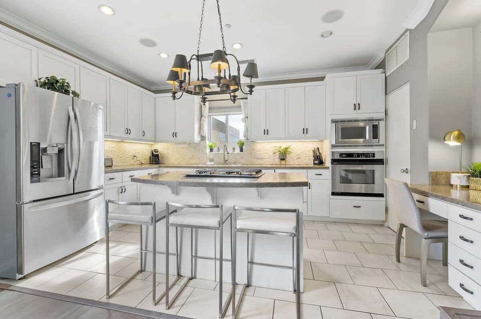 Modern chef’s kitchen featuring a top-of-the-line French door fridge, built-in oven, and sleek countertop stove—perfect for cooking up delicious meals in style and comfort!