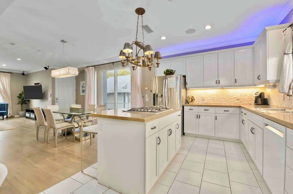 Bright and modern kitchen with glowing accent lighting, top-notch appliances, and a stylish dining area—perfect for cooking, entertaining, or enjoying a cozy night in!