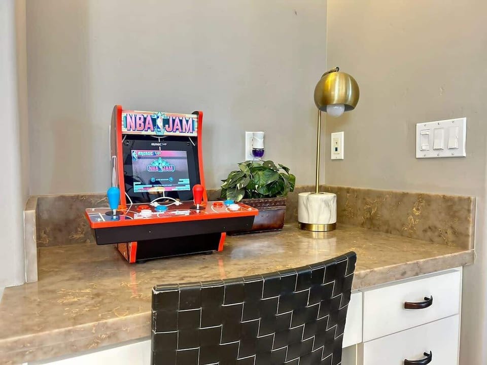 Fun and functional! This cozy desk space doubles as a mini arcade zone featuring NBA Jam—perfect for kids (and kids at heart) to enjoy some classic gaming fun or get a little work done.