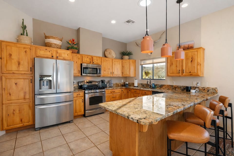 Spacious granite kitchen with island seating and stainless appliances