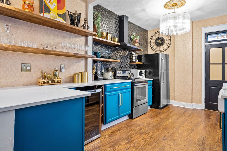 This lower level designer kitchen offers everything you need: stainless steel appliances, a wine fridge, open shelving, and luxe gold accents—all just minutes from KC’s streetcar and top dining spots.