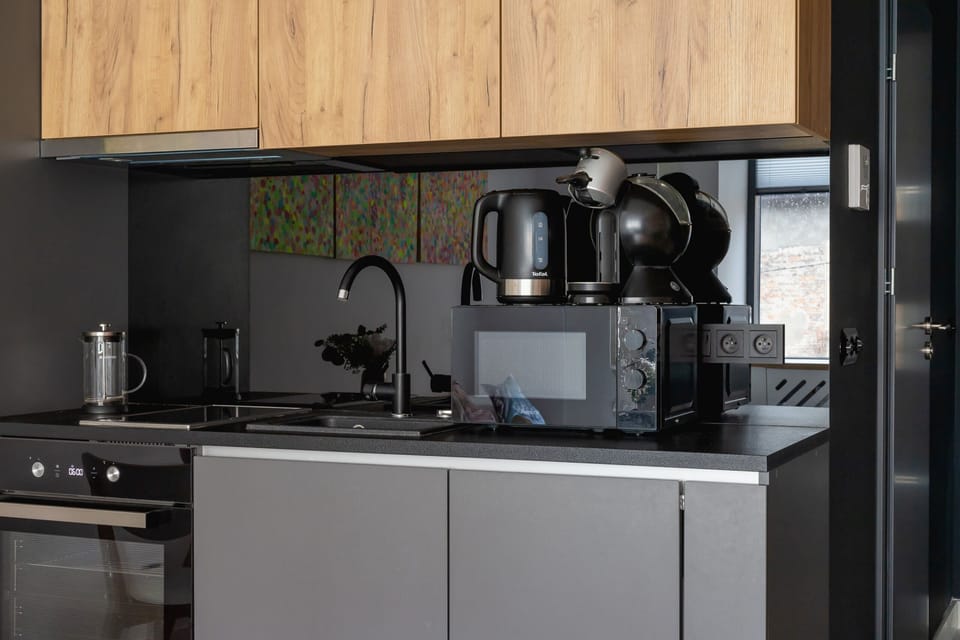 A detailed view of the studio’s kitchen, emphasizing the seamless blend of dark cabinets and warm wooden finishes.
