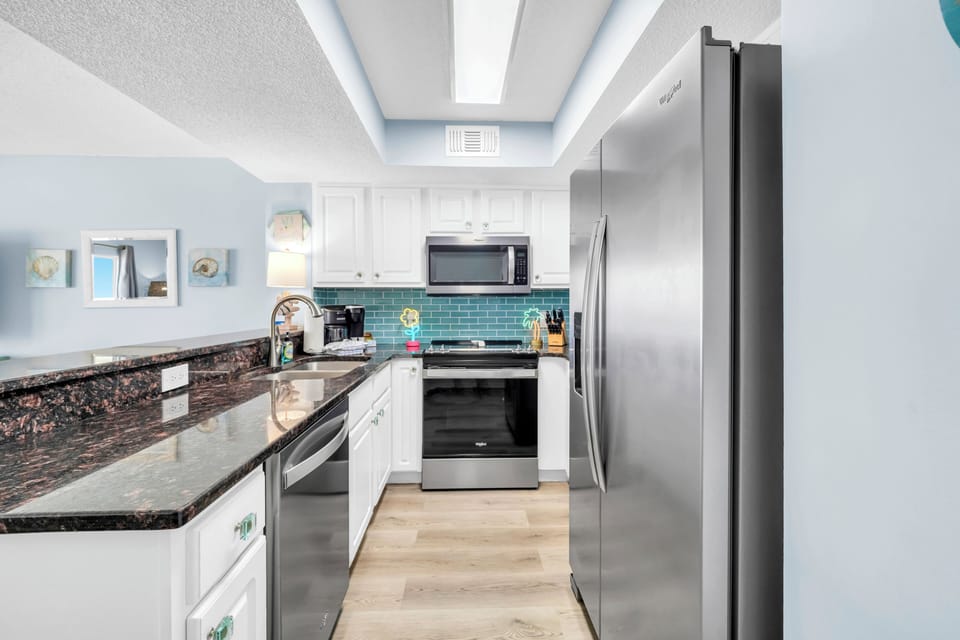Cook your favorite meals in this bright, modern kitchen with granite counters, stainless appliances, and a beautiful turquoise backsplash.