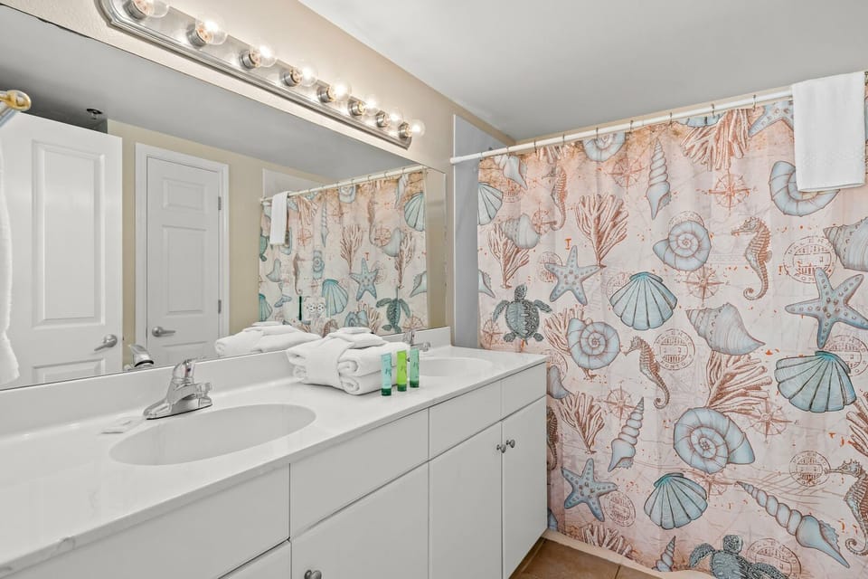 Private master bathroom with tub and shower combination for relaxing after beach days
