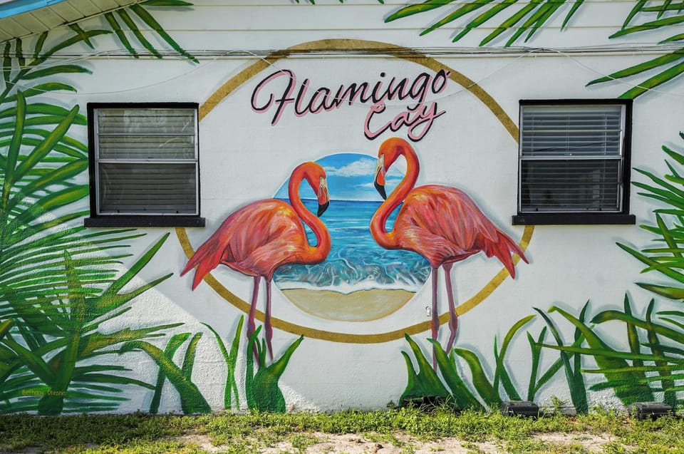 Capture the vibrant spirit of Flamingo Cay with this stunning mural of two flamingos by the sea, framed by lush tropical leaves. A perfect Instagram-worthy spot that sets the tone for your colorful coastal getaway.