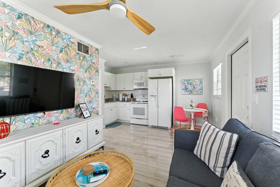 Open-concept living with a splash of color! Relax on the cozy sofa, enjoy the vibrant accent wall, and cook in the fully equipped kitchen. Bright dining nook and modern amenities make this space perfect for comfort and style