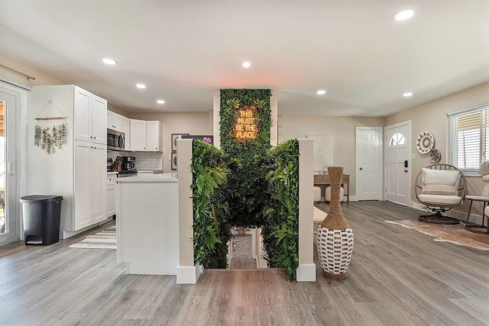 Assymetrical view of the kitchen and foyer separated by this jungle-like space