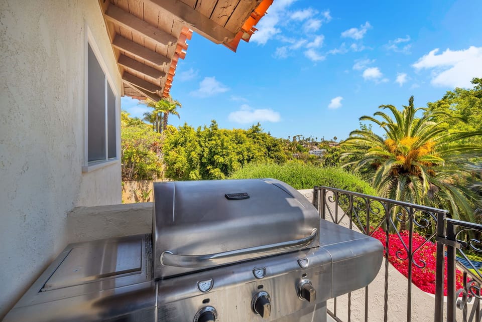 Balcony off of the dining room with a BBQ, overlooking the pool and yard