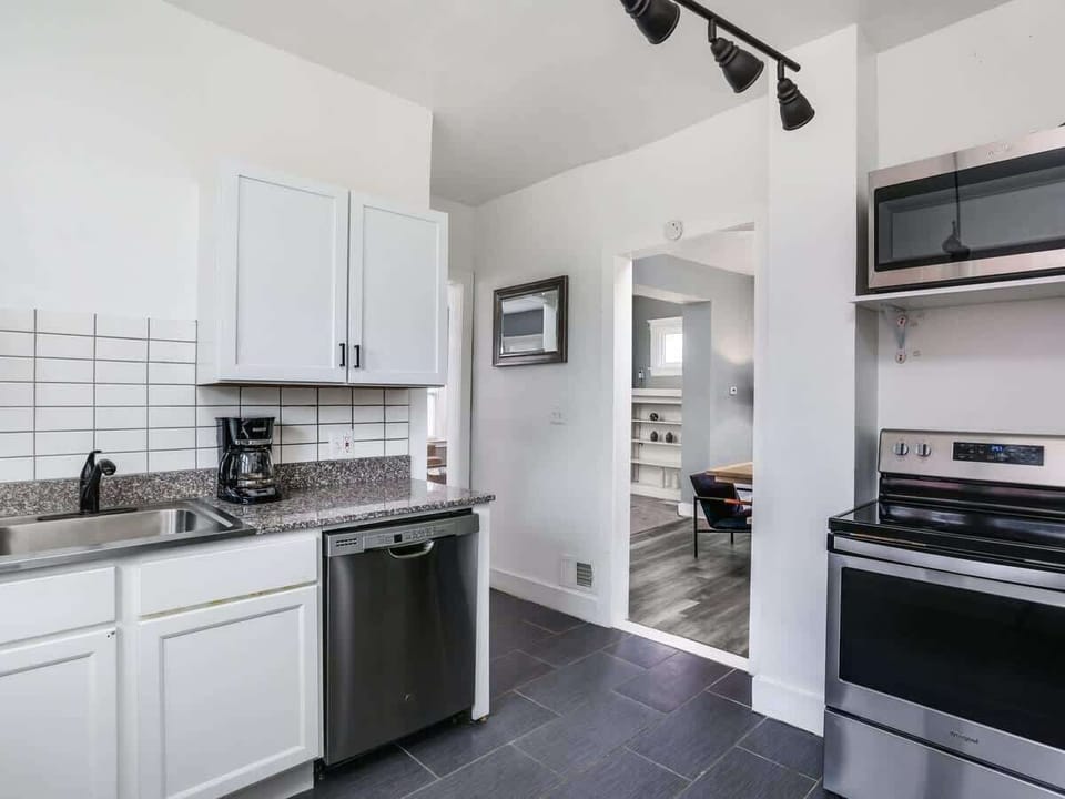 Bright kitchen with stainless steel appliances and open layout.