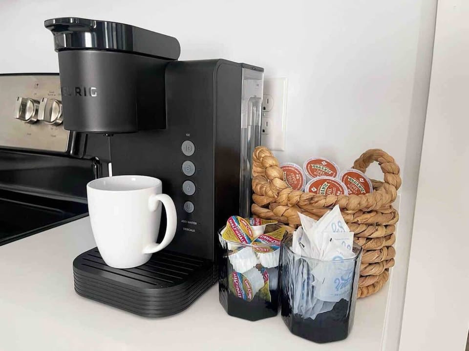 Coffee station in the kitchen featuring a new machine and mugs.