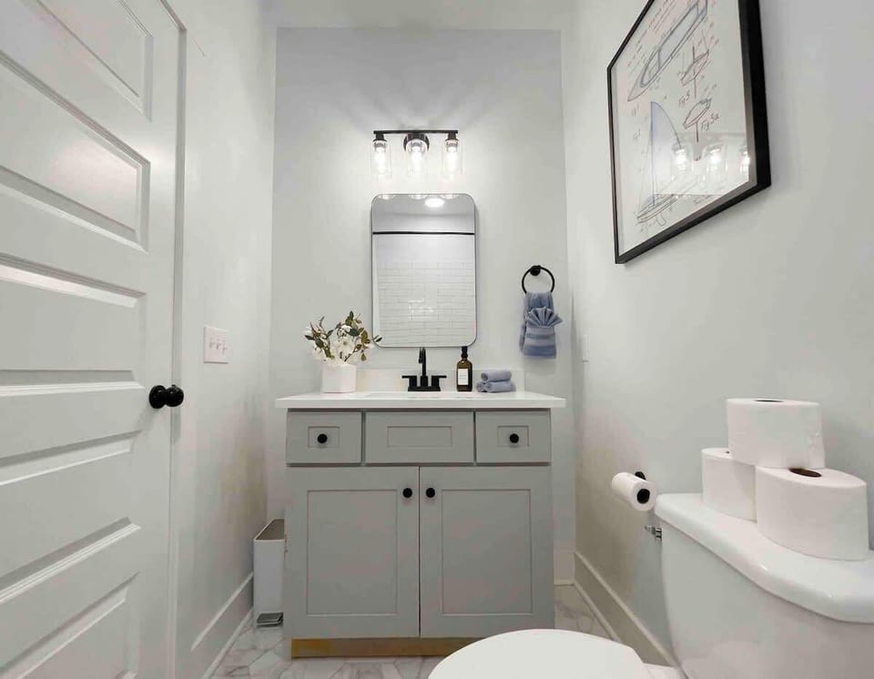 The vanity area is topped with a spacious countertop and large mirror, making getting ready an easy process. 