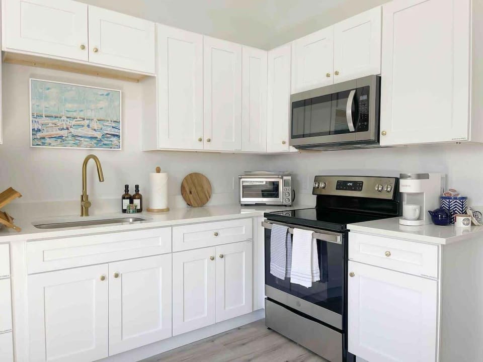 Cook with ease in this sparkling white kitchen, complete with tons of cabinets, all loaded with the tools needed for your next culinary masterpiece. 