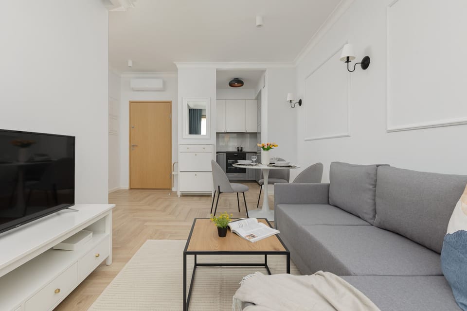 Another perspective of the living room, highlighting the modern TV setup and comfortable seating.
