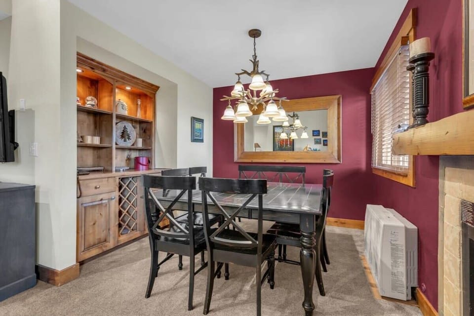 A cozy dining area is located next to the living room and features a dining table with seating for 8 situated next to a large window and the fireplace.