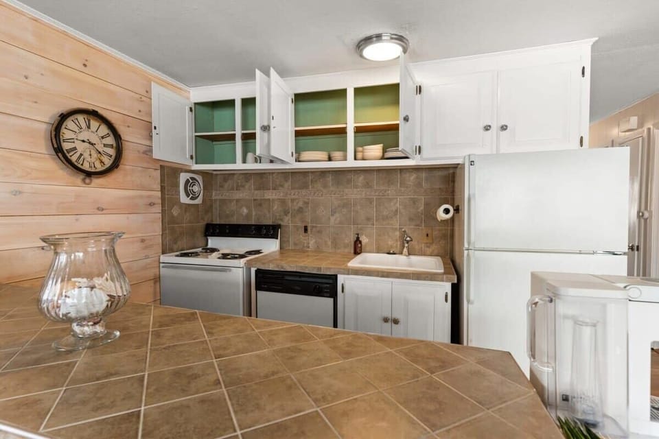 Open living room and fully-equipped kitchen, with dining room table, smart TV, and sleeper sofa.