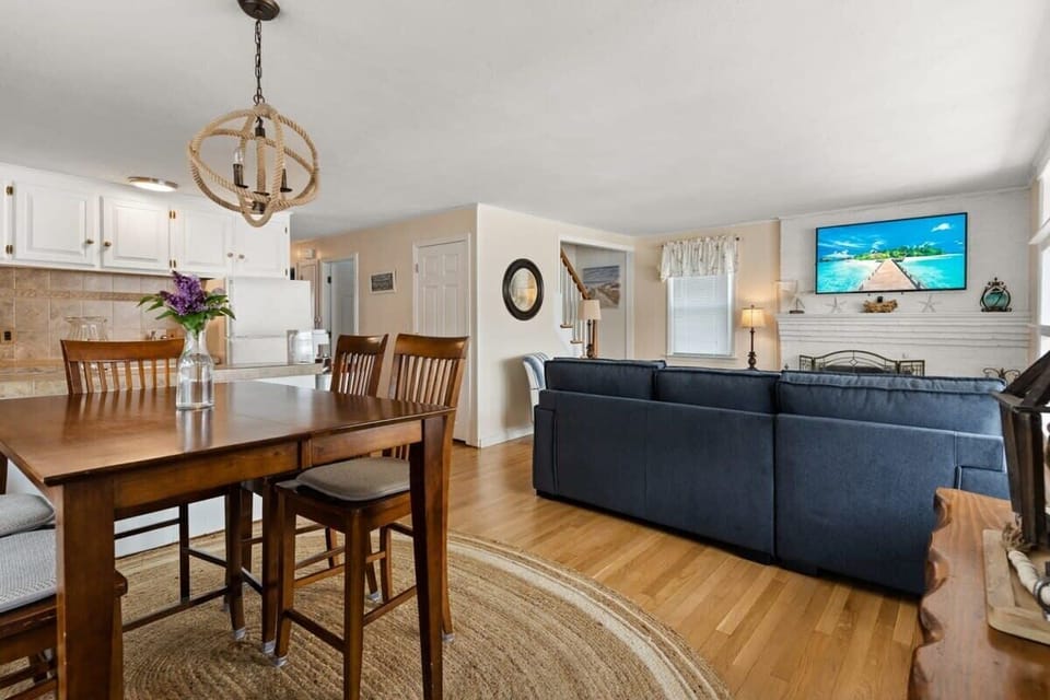 Open living room and fully-equipped kitchen, with dining room table, smart TV, and sleeper sofa.