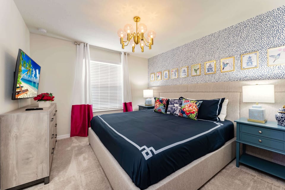 Relax in this stylish bedroom with a plush bed, vibrant decor, and modern amenities for a cozy retreat.
