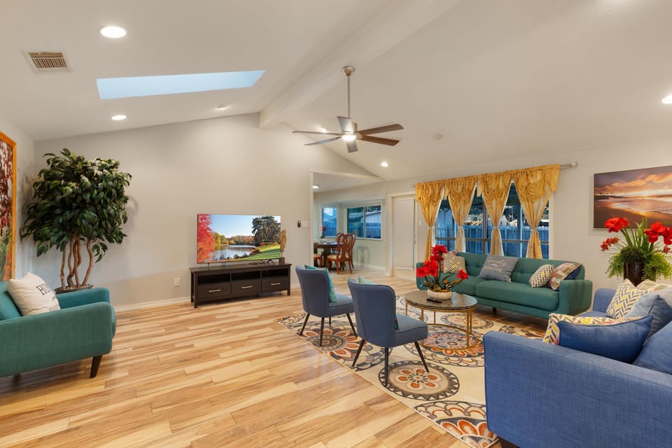 Cozy living room with a 65 inch smart TV, a sleeper couch, a loveseat and chairs